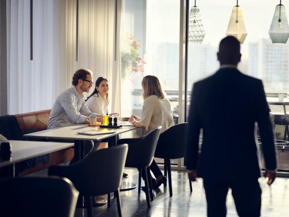 Neljä ihmistä keskustelee pöydän ympärillä Neljä ihmistä keskustelee pöydän ympärillä