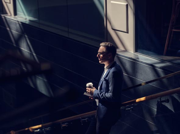 Mies, jolla on kahvikuppi kädessä